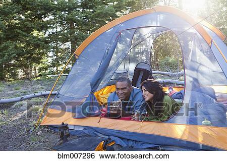 Couple camping and laying in tent View Large Photo Image Stock Photograph - Couple camping and laying in tent. Fotosearch