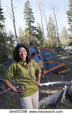 Stock Photo - Couple camping and standing outside tent. Fotosearch