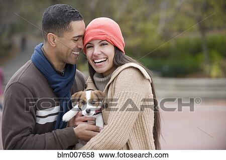 Couple holding puppy View Large Photo Image Stock Photo - Couple holding puppy. Fotosearch
