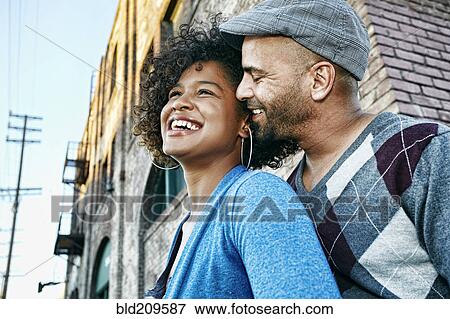 Couple hugging below urban building View Large Photo Image Stock Photo - Couple hugging below urban building. Fotosearch