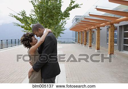 Couple hugging in courtyard View Large Photo Image Stock Photo - Couple hugging in courtyard. Fotosearch