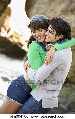 Stock Image - Couple hugging on beach. Fotosearch