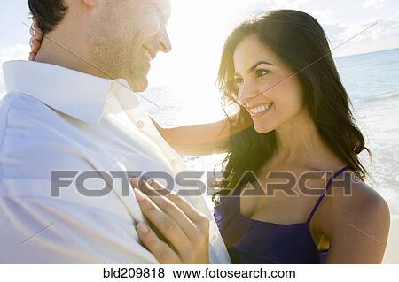 Stock Photo - Couple hugging on beach. Fotosearch