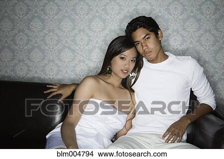 Picture - Couple hugging on sofa. Fotosearch