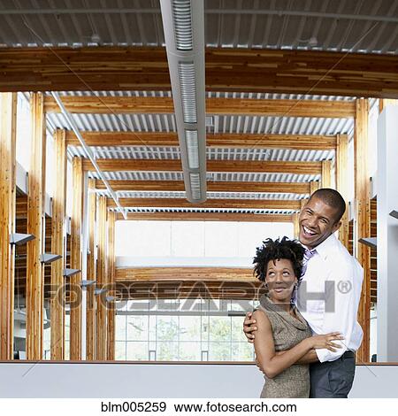 Stock Photo - Couple laughing in empty office space. Fotosearch