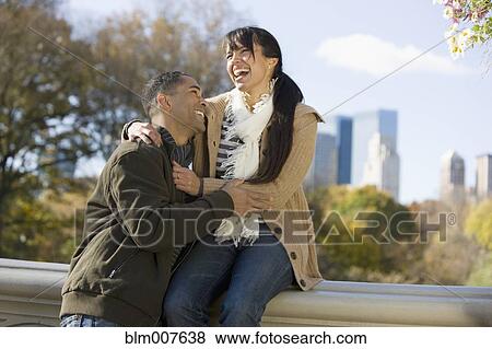 Stock Photo - Couple laughing in park. Fotosearch