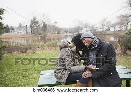 Stock Photograph - Couple laughing together in park. Fotosearch