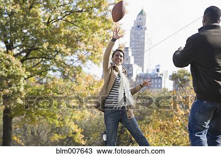 Couple playing football in park View Large Photo Image Stock Image - Couple playing football in park. Fotosearch