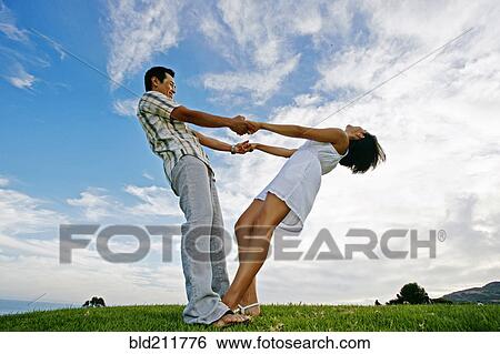 Couple playing in rural landscape View Large Photo Image Stock Photograph - Couple playing in rural landscape. Fotosearch