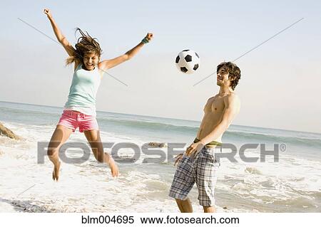 Couple playing with soccer ball on beach View Large Photo Image Stock Photography - Couple playing with soccer ball on beach. Fotosearch