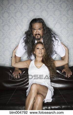 Stock Image - Couple posing in living room. Fotosearch