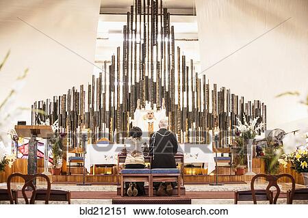 Stock Image - Couple praying at wedding in church. Fotosearch