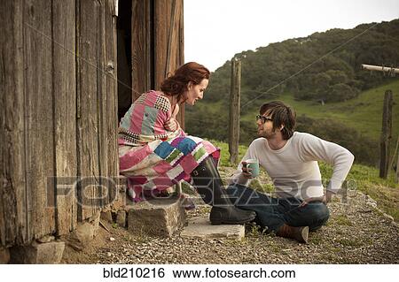 Stock Photograph - Couple relaxing by barn. Fotosearch