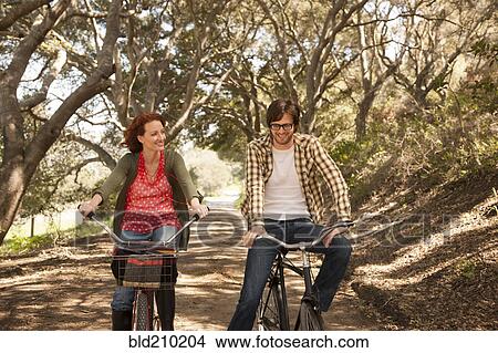 Couple riding bicycles on rural road View Large Photo Image Picture - Couple riding bicycles on rural road. Fotosearch