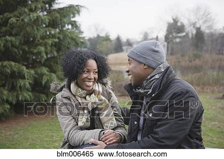 Stock Photography - Couple sitting together in park. Fotosearch