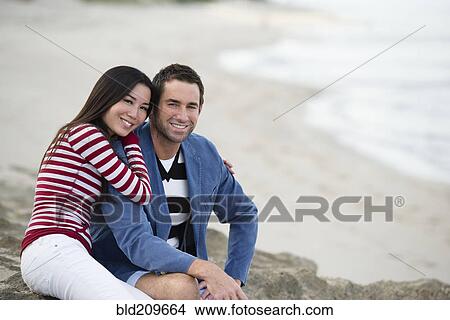 Couple smiling together on beach View Large Photo Image Picture - Couple smiling together on beach. Fotosearch