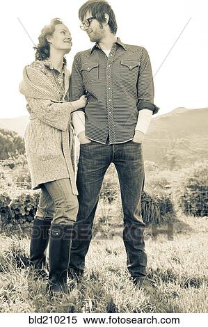 Stock Photography - Couple standing in rural field. Fotosearch