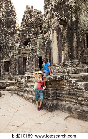 Stock Photo - Couple visiting ancient temple, Angkor, Siem Reap, Cambodia. Fotosearch