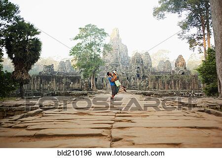 Stock Photograph - Couple visiting ancient temple, Angkor, Siem Reap, Cambodia. Fotosearch