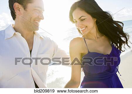 Stock Photo - Couple walking on beach. Fotosearch