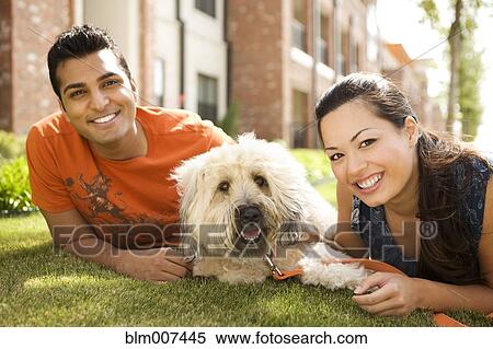 Couple with dog laying on grass View Large Photo Image Stock Photography - Couple with dog laying on grass. Fotosearch