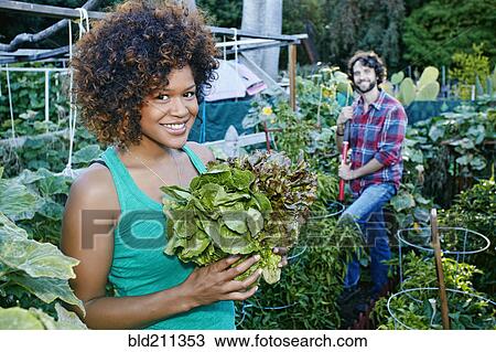 Stock Image - Couple working in garden. Fotosearch
