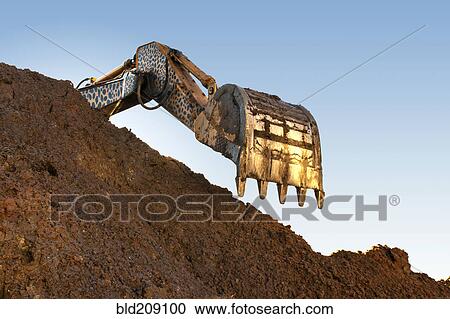 Earth mover scoop over heap of dirt in quarry View Large Photo Image Stock Image - Earth mover scoop over heap of dirt in quarry. Fotosearch