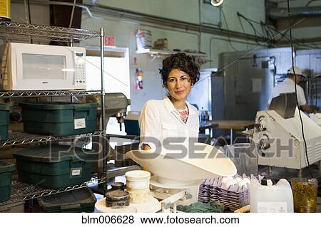 Stock Photo - Ecuadorian bakery owner standing in kitchen. Fotosearch