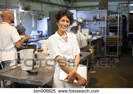 Stock Photography - Ecuadorian bakery owner standing in kitchen. Fotosearch