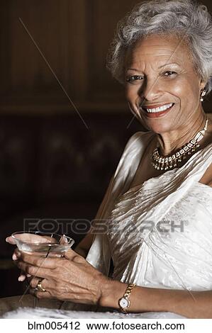 Stock Image - Elegant African American woman drinking martini. Fotosearch