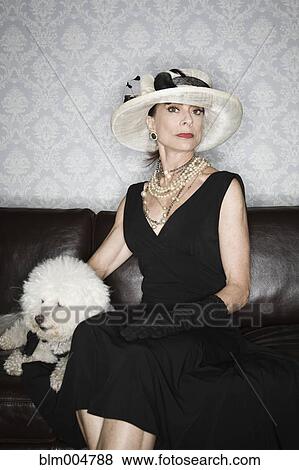 Elegant Caucasian woman on sofa with dog View Large Photo Image Stock Photo - Elegant Caucasian woman on sofa with dog. Fotosearch