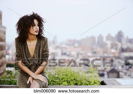 Elegant mixed race woman sitting on urban rooftop View Large Photo Image Stock Image - Elegant mixed race woman sitting on urban rooftop. Fotosearch