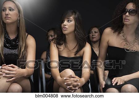 Stock Photo - Elegant women watching fashion show. Fotosearch