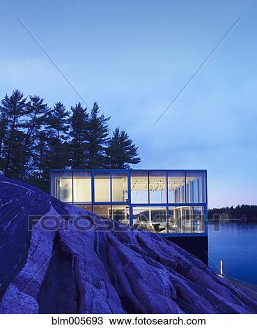 Stock Image - Exterior of modern house near lake. Fotosearch