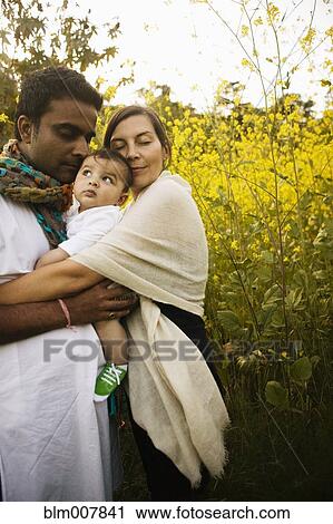 Stock Image - Family hugging in field. Fotosearch