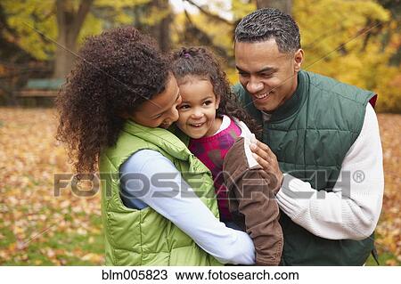 Stock Image - Family hugging outdoors in autumn. Fotosearch