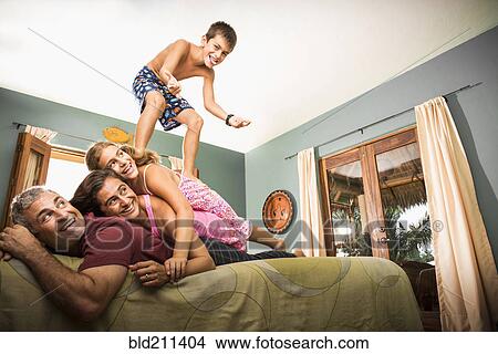 Family playing together on bed View Large Photo Image Picture - Family playing together on bed. Fotosearch