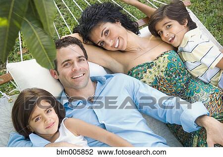 Stock Image - Family relaxing in hammock. Fotosearch