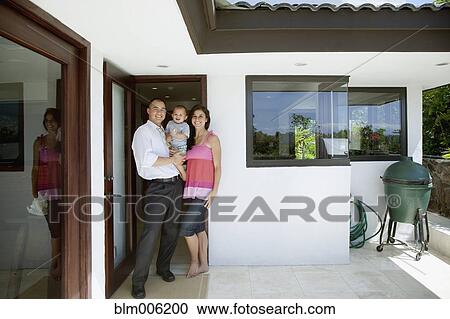 Stock Image - Family smiling on patio. Fotosearch