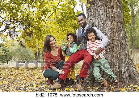 Family smiling together in park View Large Photo Image Stock Photography - Family smiling together in park. Fotosearch