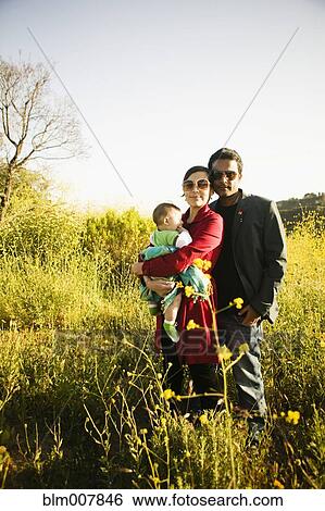 Stock Photograph - Family standing together in field. Fotosearch