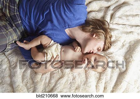 Father and baby laying on blanket View Large Photo Image Stock Photo - Father and baby laying on blanket. Fotosearch