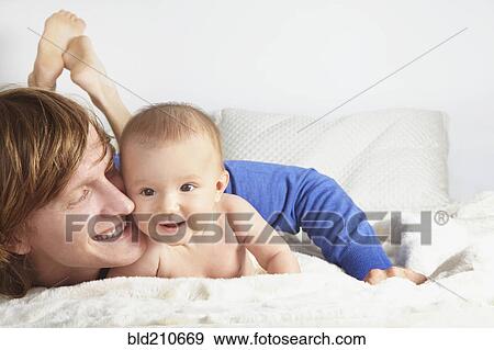 Stock Photo - Father and baby laying on blanket. Fotosearch