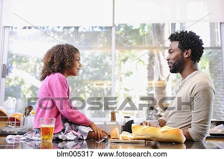 Father and daughter eating in kitchen View Large Photo Image Stock Photo - Father and daughter eating in kitchen. Fotosearch