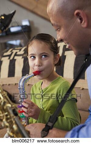 Father and daughter playing saxophone together View Large Photo Image Stock Photo - Father and daughter playing saxophone together. Fotosearch