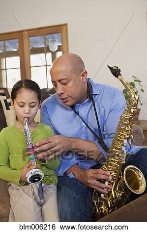 Stock Photograph - Father and daughter playing saxophone together. Fotosearch