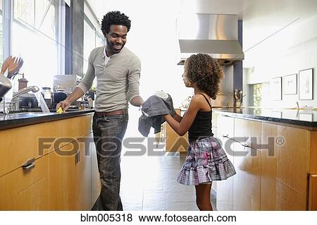 Stock Photo - Father and daughter washing dishes. Fotosearch