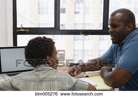 Stock Photograph - Father and son doing homework. Fotosearch
