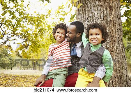 Father and sons smiling in park View Large Photo Image Picture - Father and sons smiling in park. Fotosearch