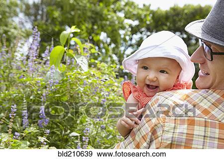 Father carrying baby daughter in park View Large Photo Image Stock Photo - Father carrying baby daughter in park. Fotosearch